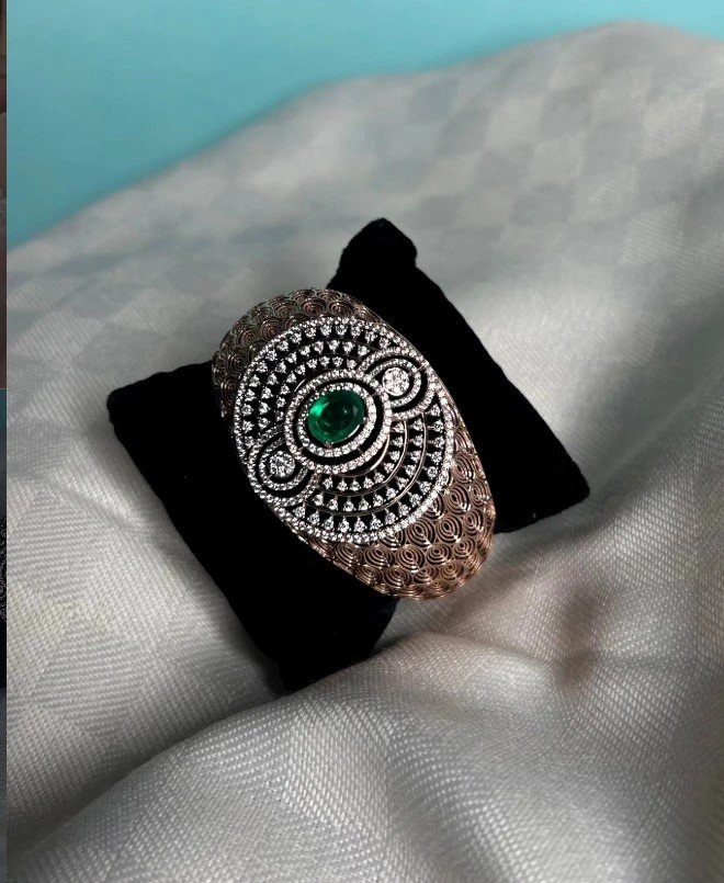 Ornate ring with a green centre stone and detailed setting