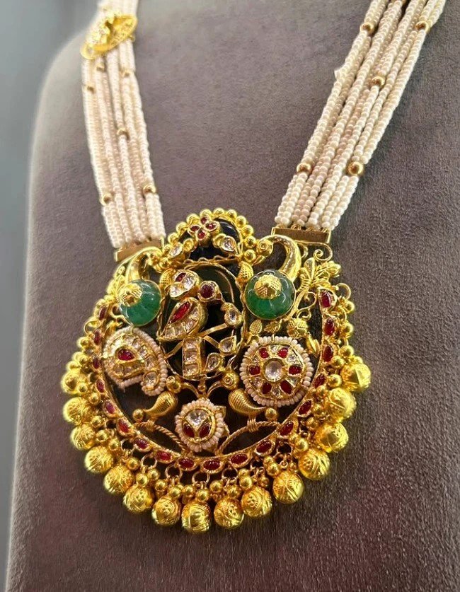 Traditional gold-tone pendant with pearl strands and coloured accents